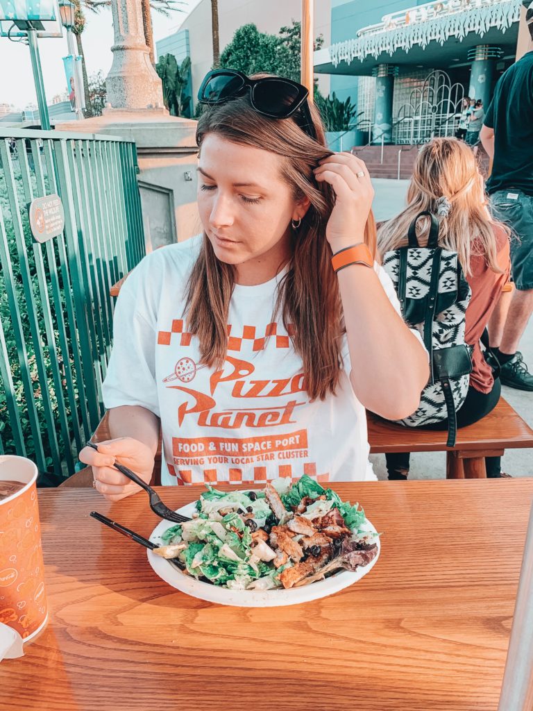 girl sitting at table in Disney's Hollywood Studios with a southwest chicken salad.